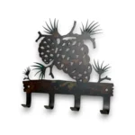 Hand-painted pine cone metal key holder with four hooks, rustic weathered finish, and woodland cabin decor style.