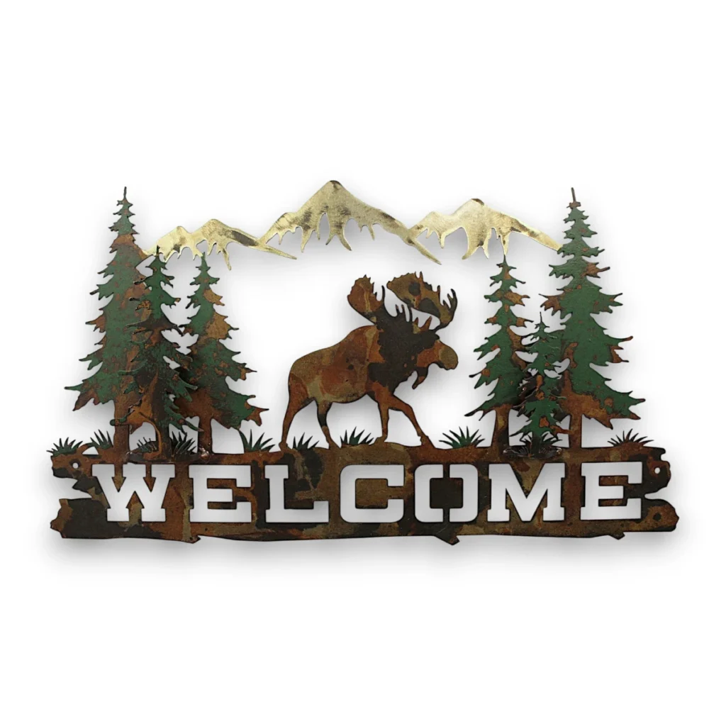 Hand-painted moose welcome metal wall art with pine trees, mountains, rustic weathered finish, and cabin lodge decor style.