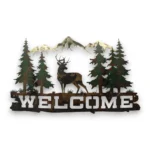 Hand-painted mule deer welcome metal wall art with pine trees, mountains, rustic weathered finish, and cabin lodge decor style.