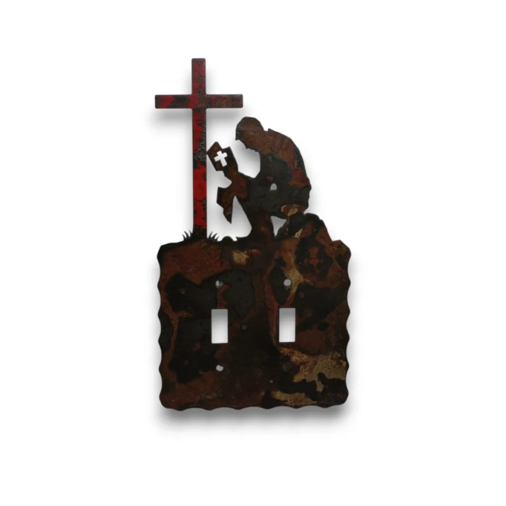 Hand-painted double toggle metal light switch cover with praying cowboy, red cross, rustic western finish, and faith-inspired decor style.